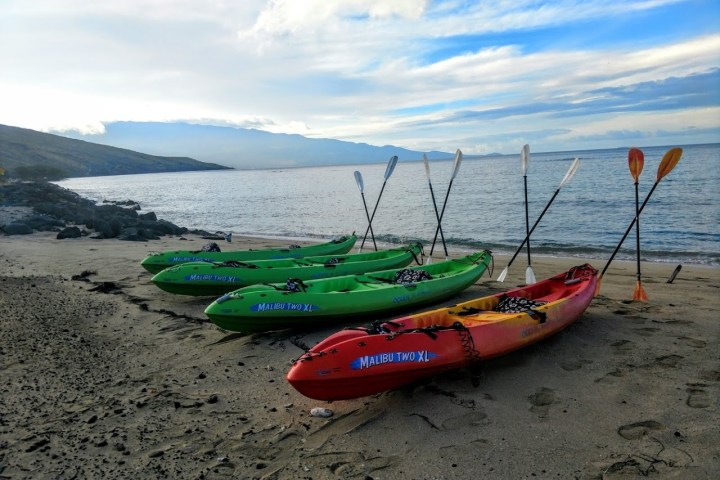 a boat sitting on top of a sandy beach